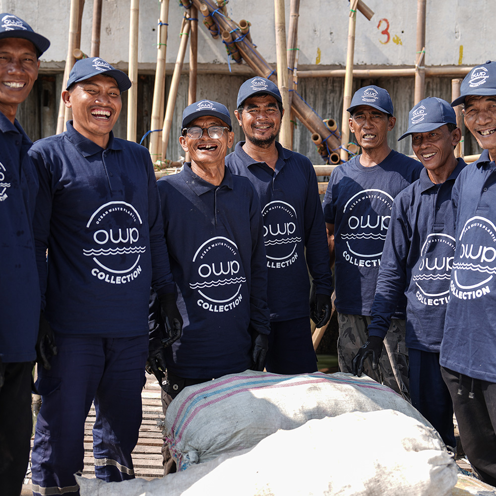 OWP Collection team in uniform next to bags of collected plastic