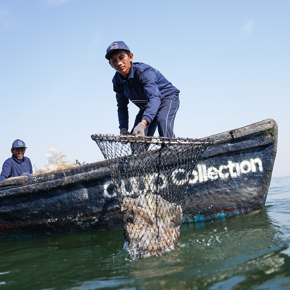 Collector pulling plastic out of the water with a net
